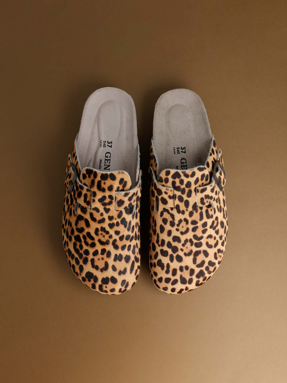 A pair of Genuins Riva clogs in leopard print, seen from above